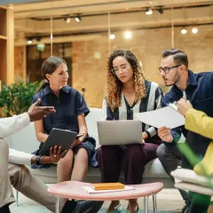 A diverse team brainstorms in a modern, open office, showcasing effective collaborative work spaces.