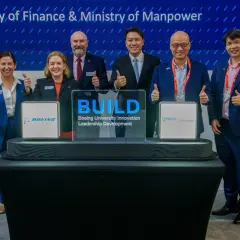 Six individuals in suits give thumbs up at a ceremony for Boeing University Innovation Leadership Development.
