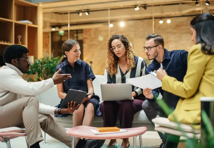 A diverse team brainstorms in a modern, open office, showcasing effective collaborative work spaces.