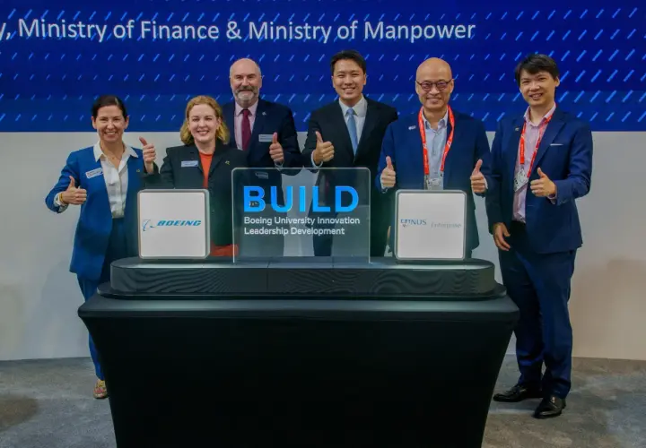 Six individuals in suits give thumbs up at a ceremony for Boeing University Innovation Leadership Development.