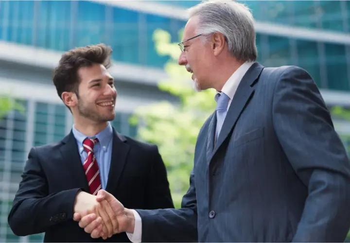 Two businessmen shake hands, symbolizing a smooth succession planning for their family business.