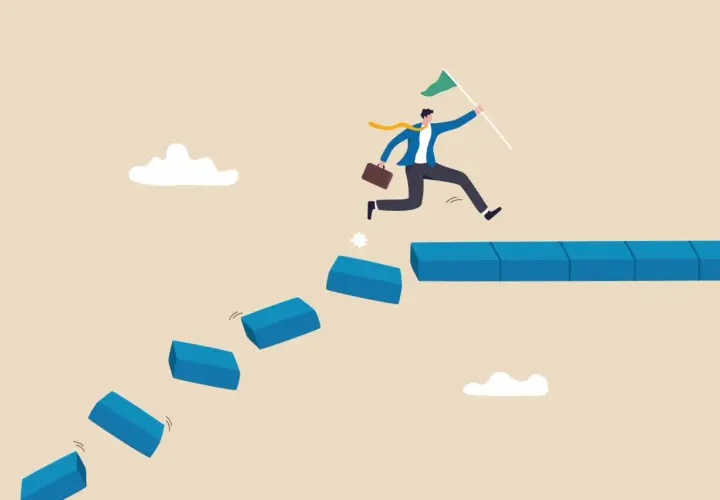 A businessman leaps across broken steps, holding a flag, illustrating how to handle a crisis situation by taking bold steps towards success.