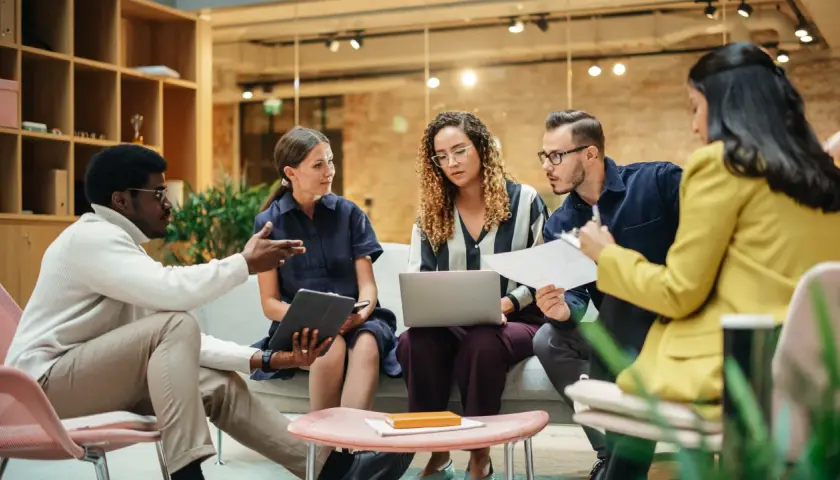 A diverse team brainstorms in a modern, open office, showcasing effective collaborative work spaces.