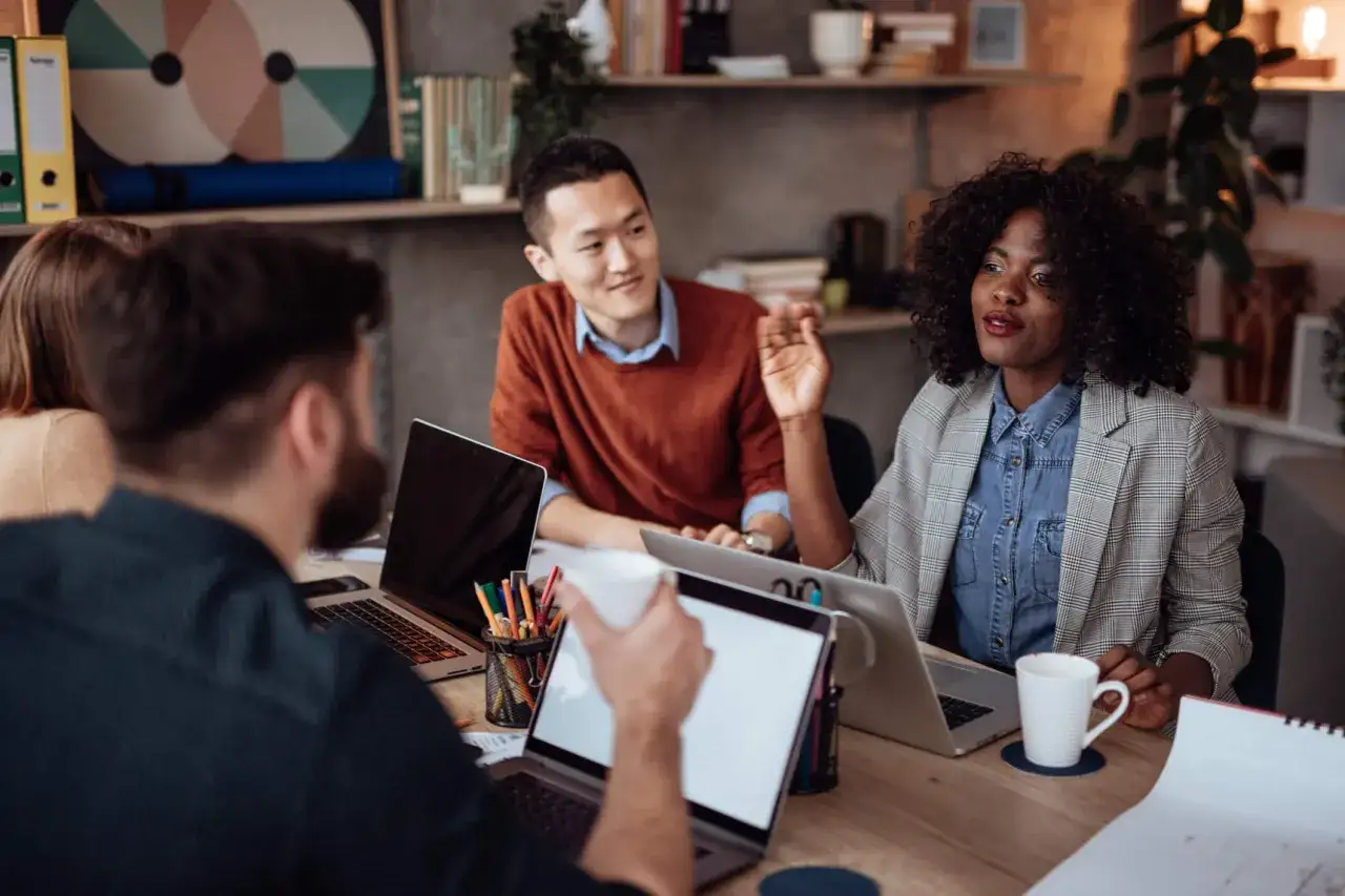 A master mentor guides her team during a collaborative meeting, sharing insights and fostering growth.
