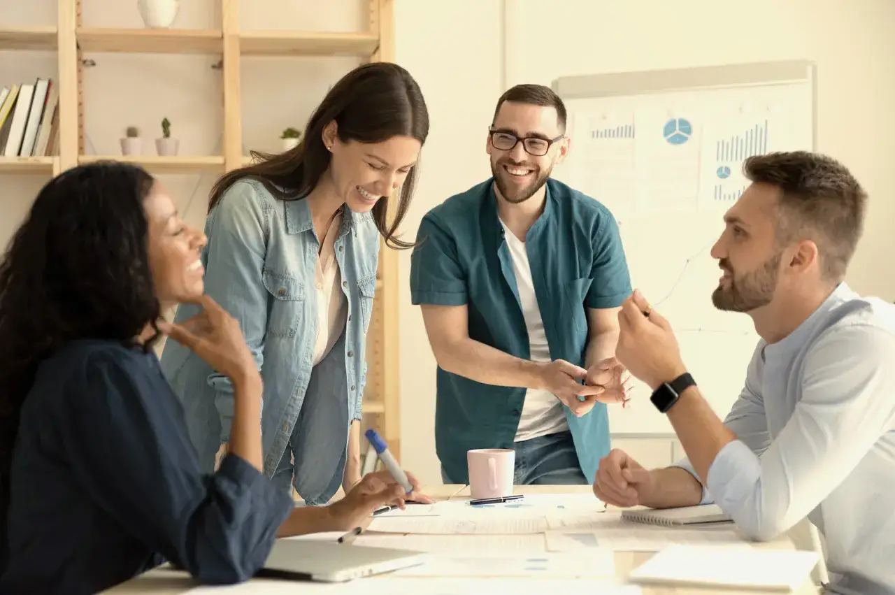 Team brainstorming session. A woman laughs while holding a marker, ready to ask questions to her boss.