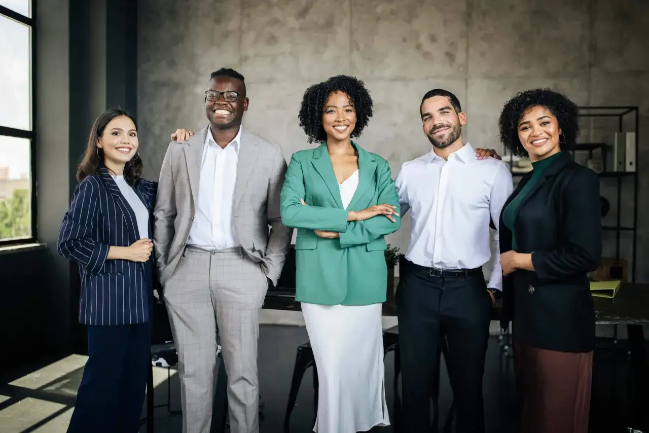 A diverse team of five professionals stands confidently, showcasing their best attributes in stylish business attire.