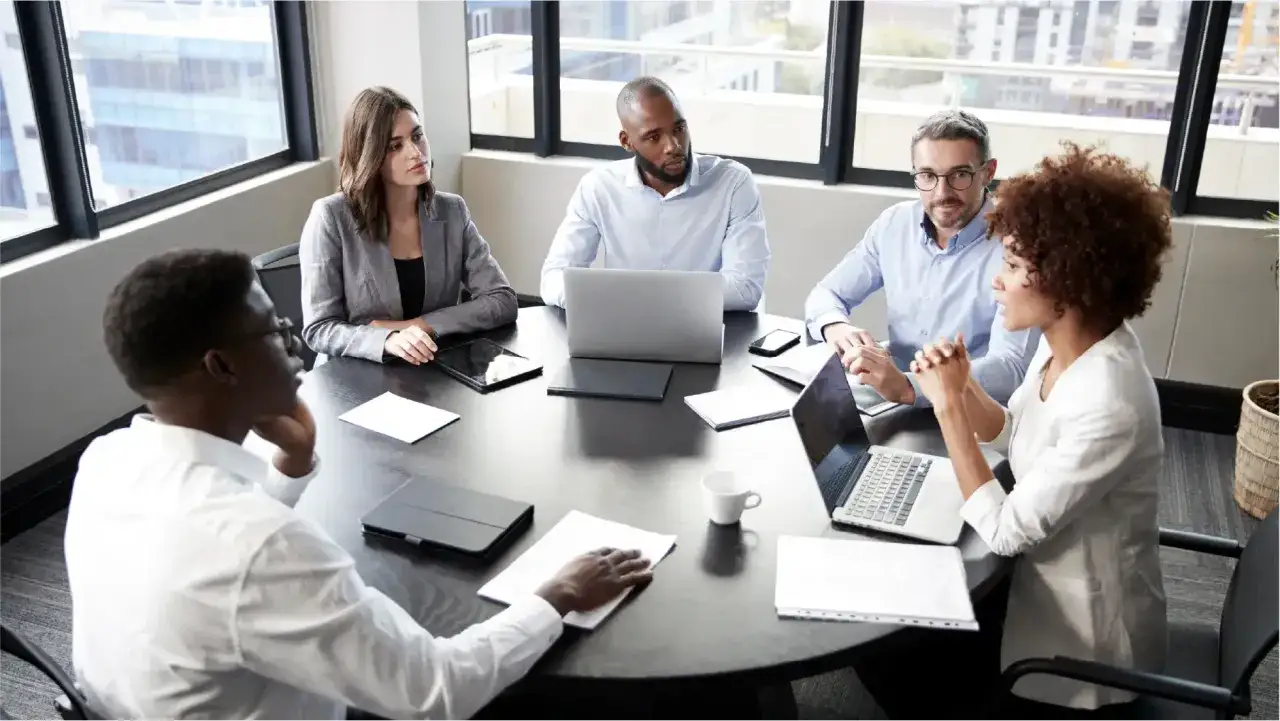 Diverse team in a modern boardroom, discussing strategies. This scene exemplifies effective internal marketing, fostering collaboration and shared vision.