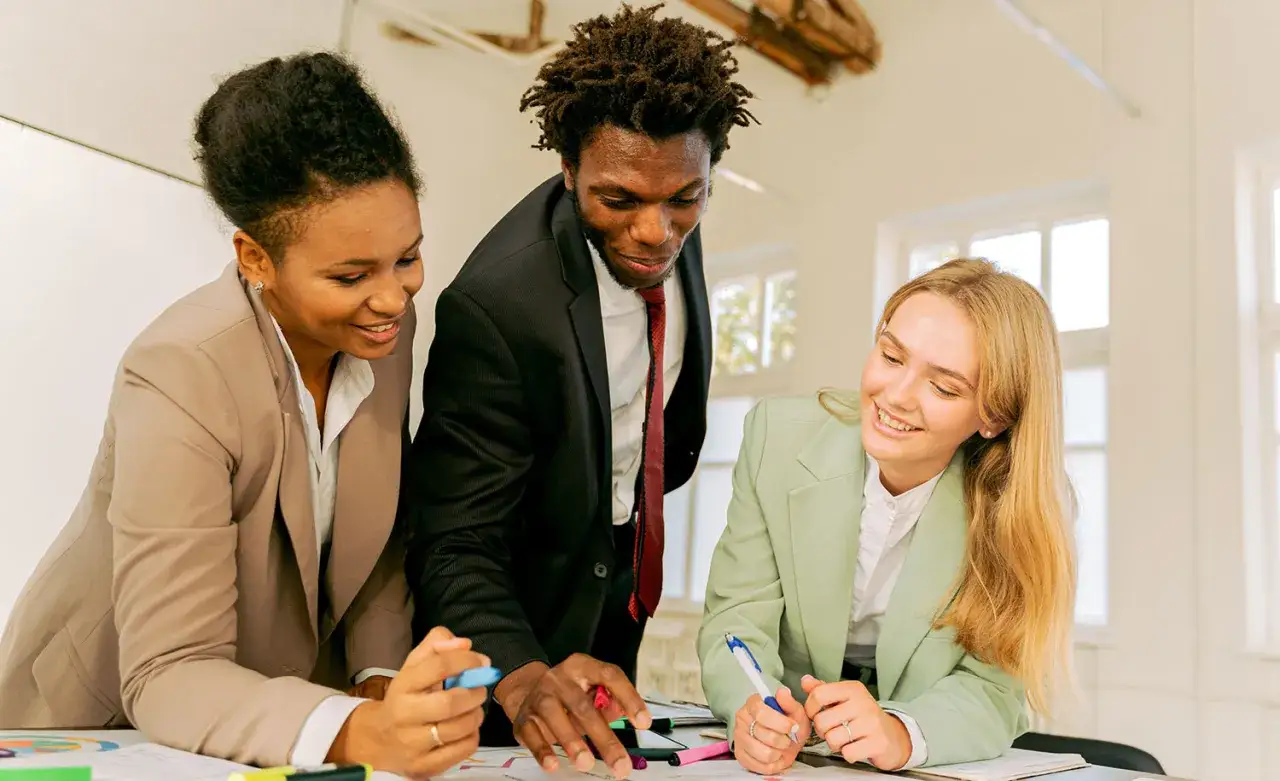 Three diverse colleagues collaborate, showing that introverted leaders can foster a positive and productive team environment.