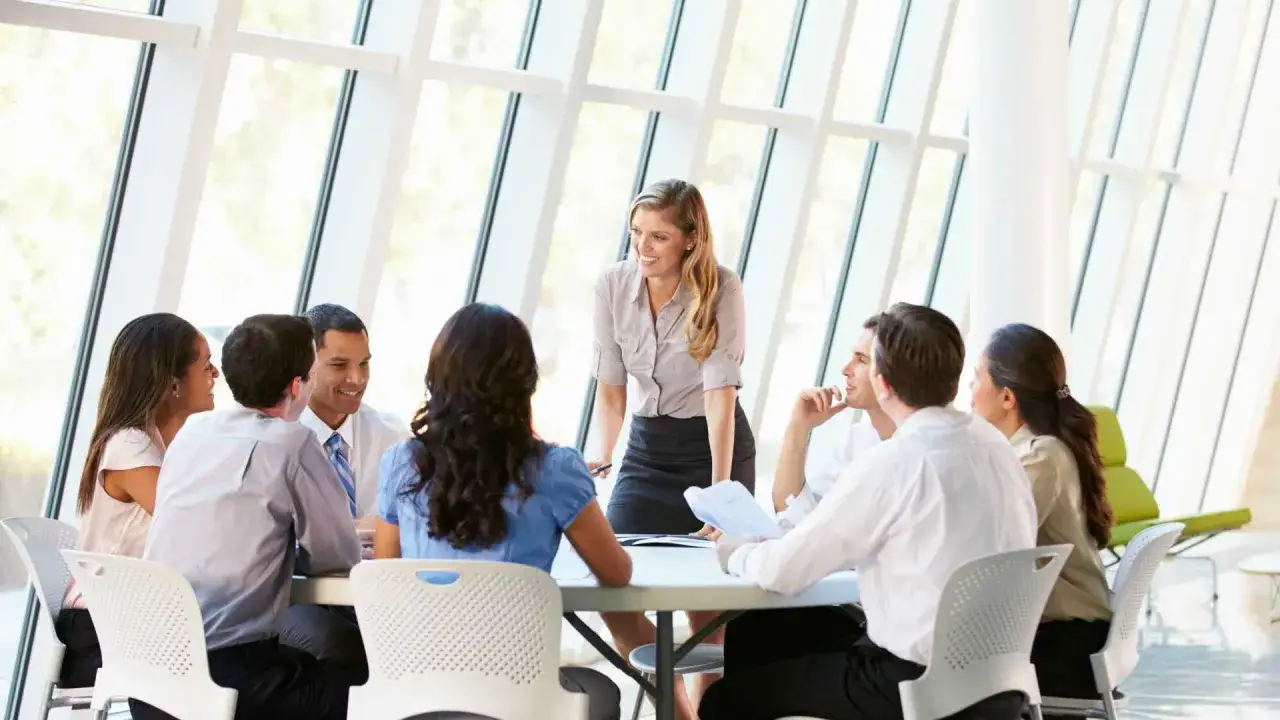 A team collaborates in a bright meeting room, demonstrating how to create psychological safety through open discussion and engagement.