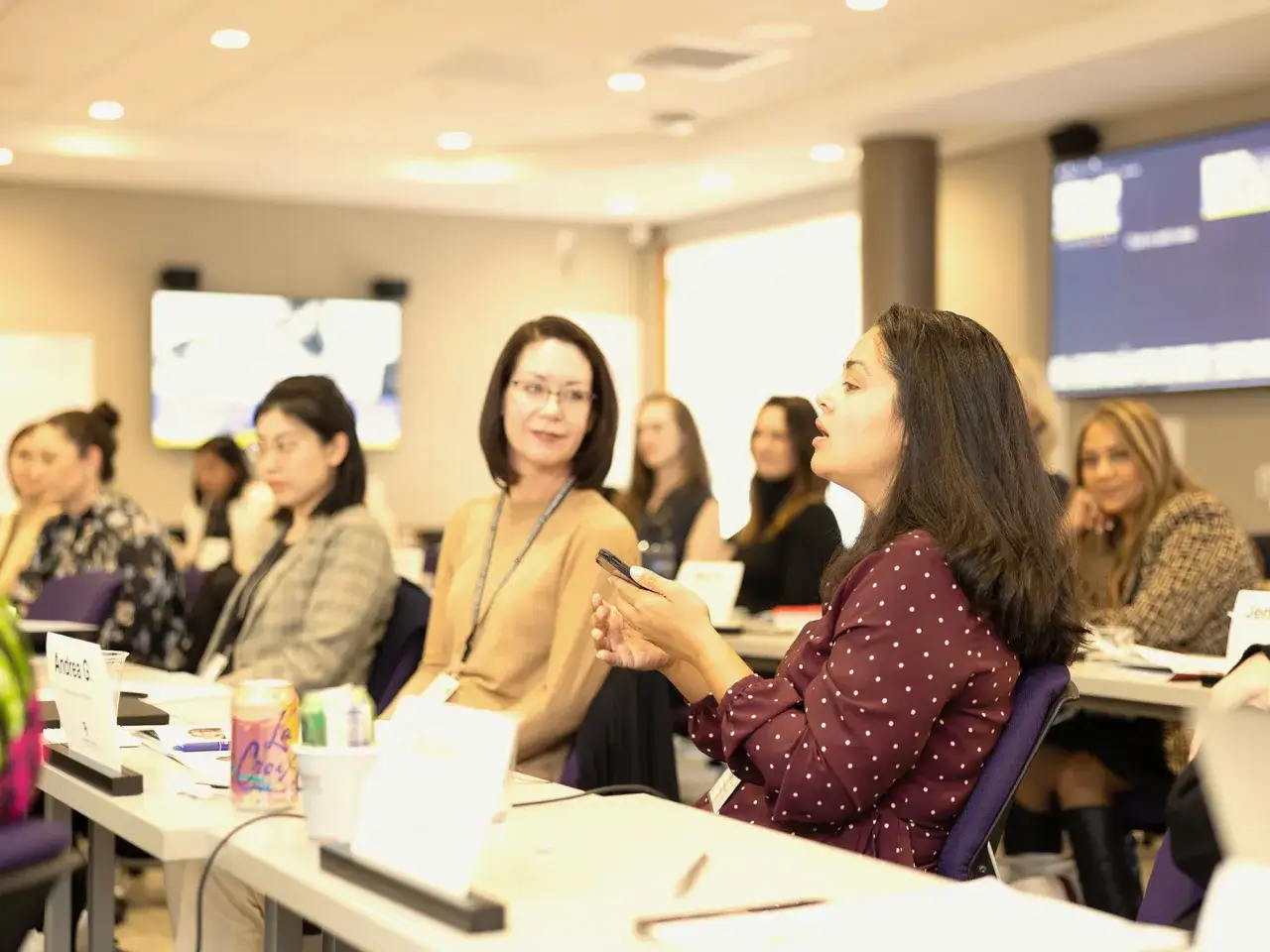 Women engage in a lively discussion during in-person leadership programs.