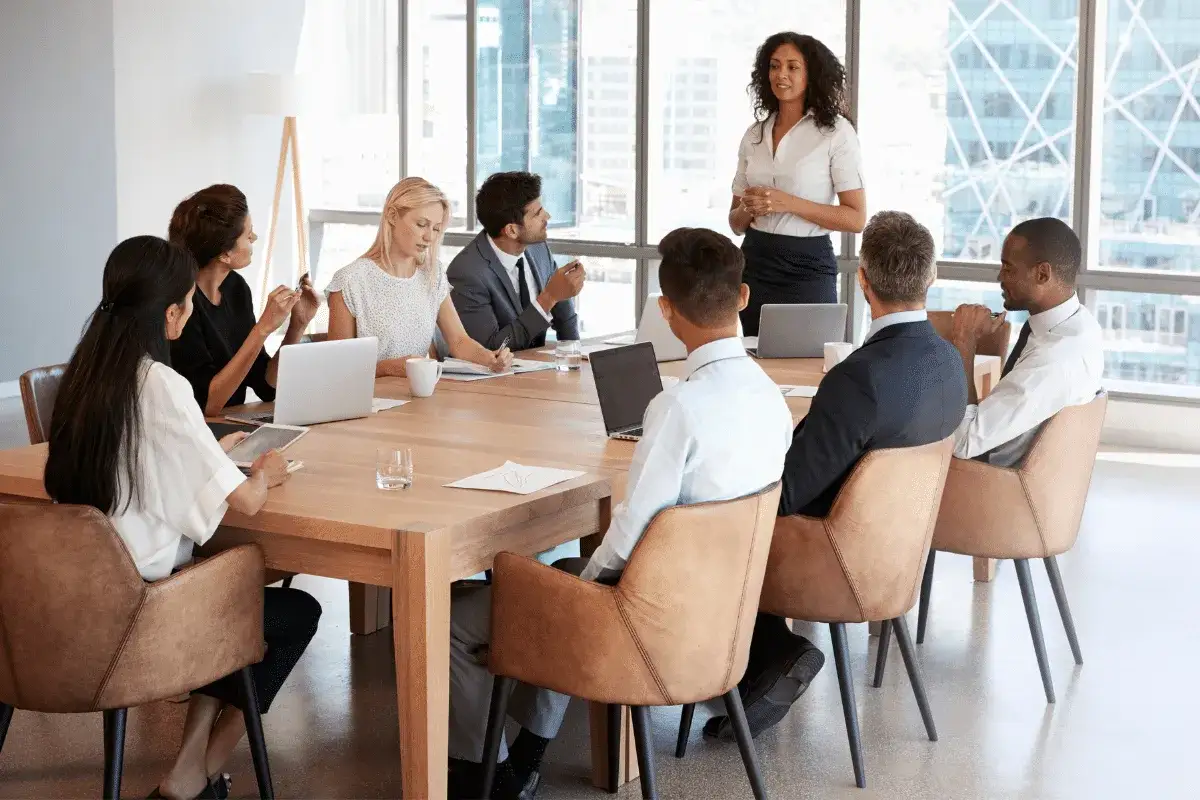 Diverse professionals in a meeting, discussing strategy. This scene illustrates how to get on a board of directors through collaboration and presentation.