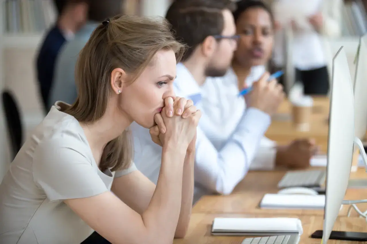 A woman looks stressed, hands clasped to her mouth. These are signs it's time to leave your job.